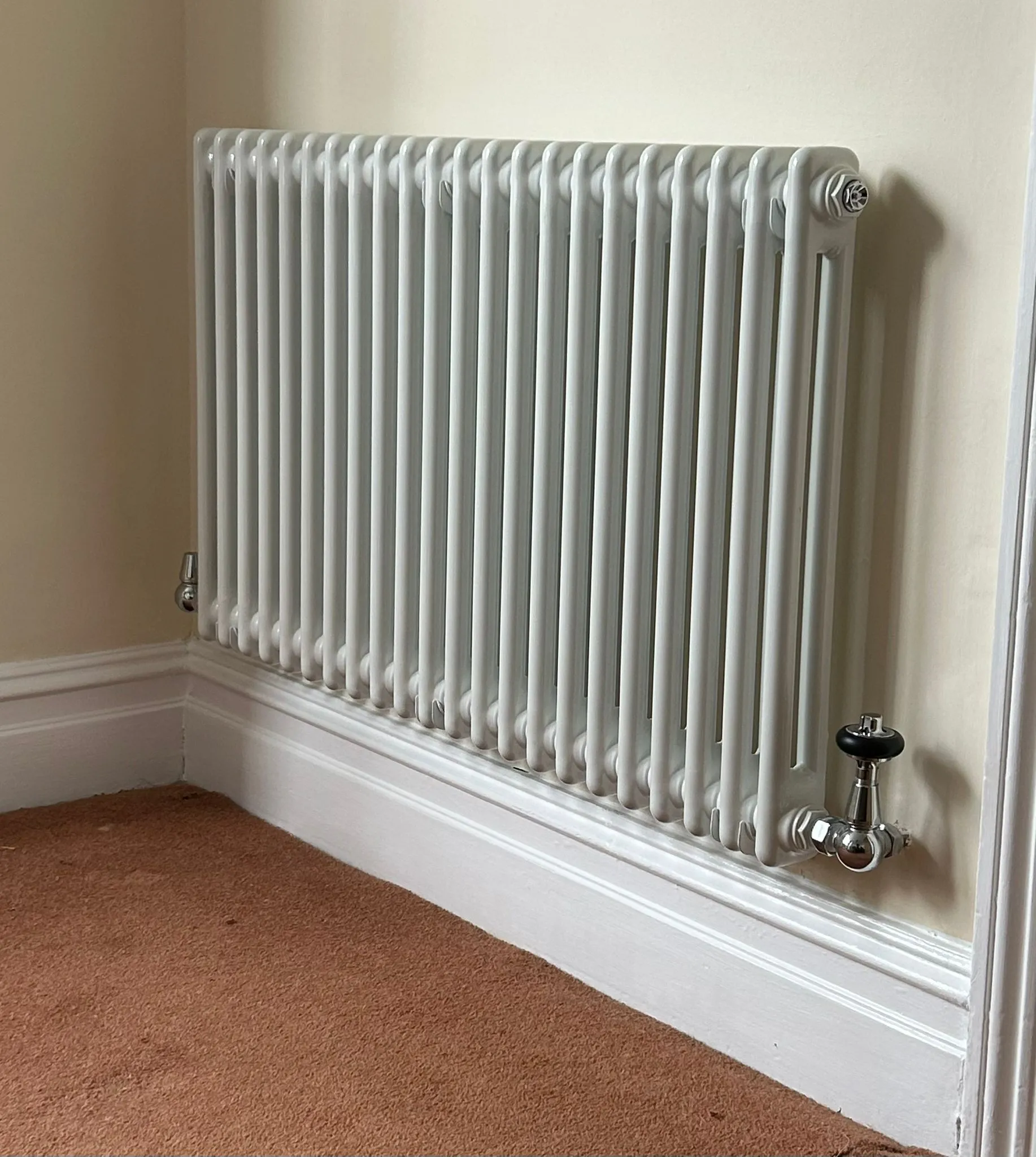 A radiator in a corner of a room.