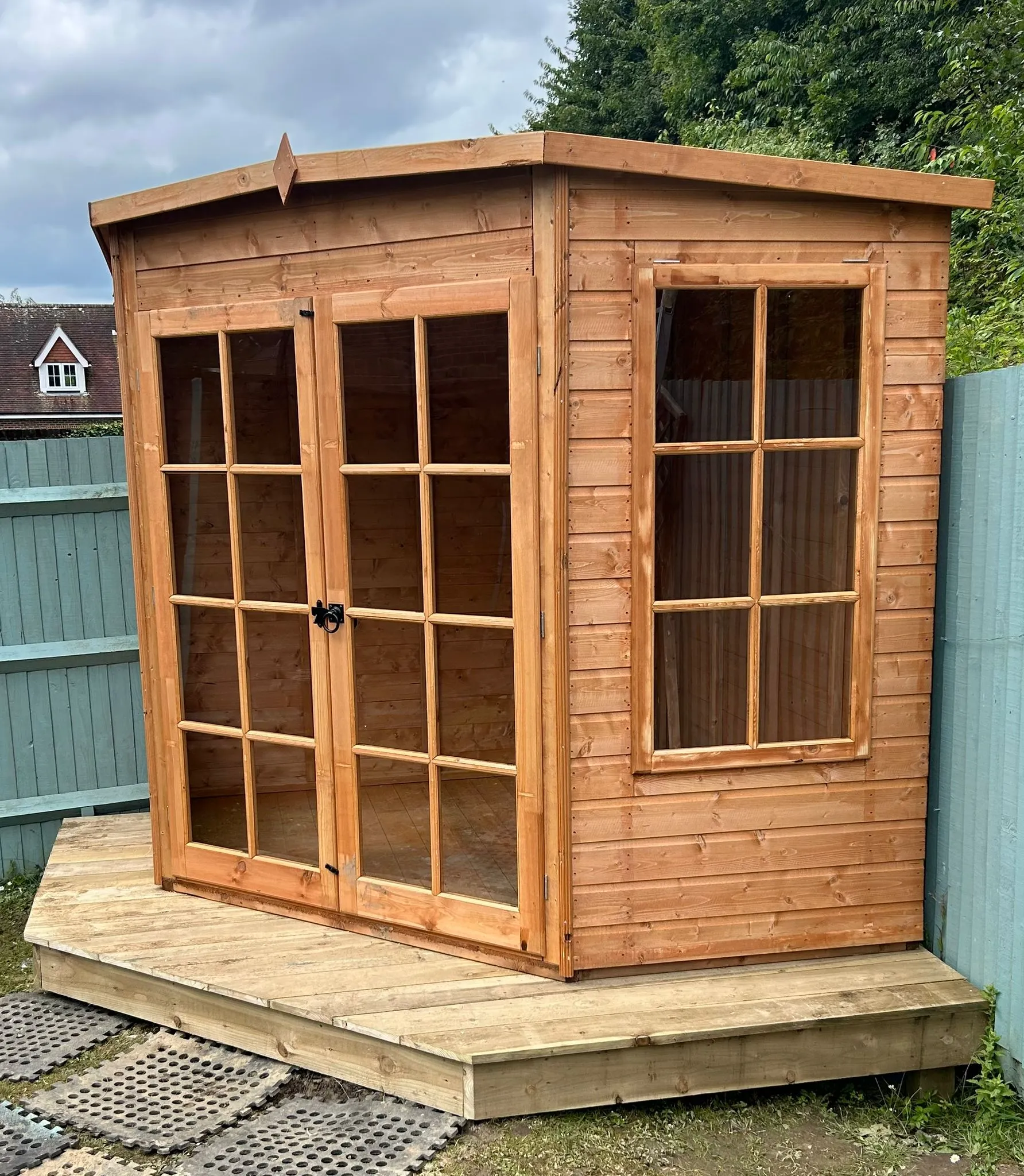 a wooden shed with windows on the side of it