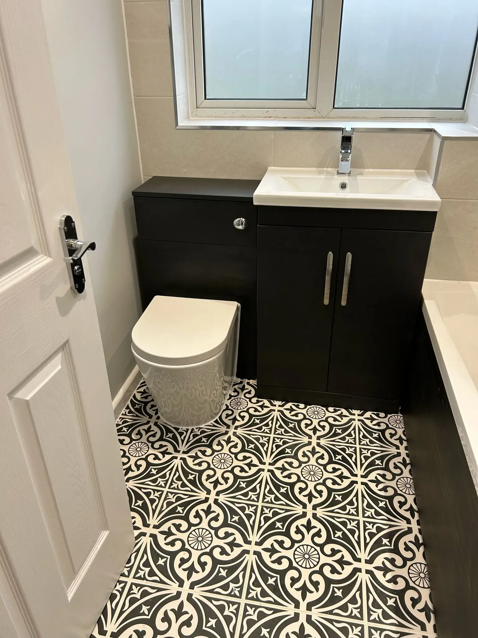 A bathroom with a toilet, sink, and bathtub.