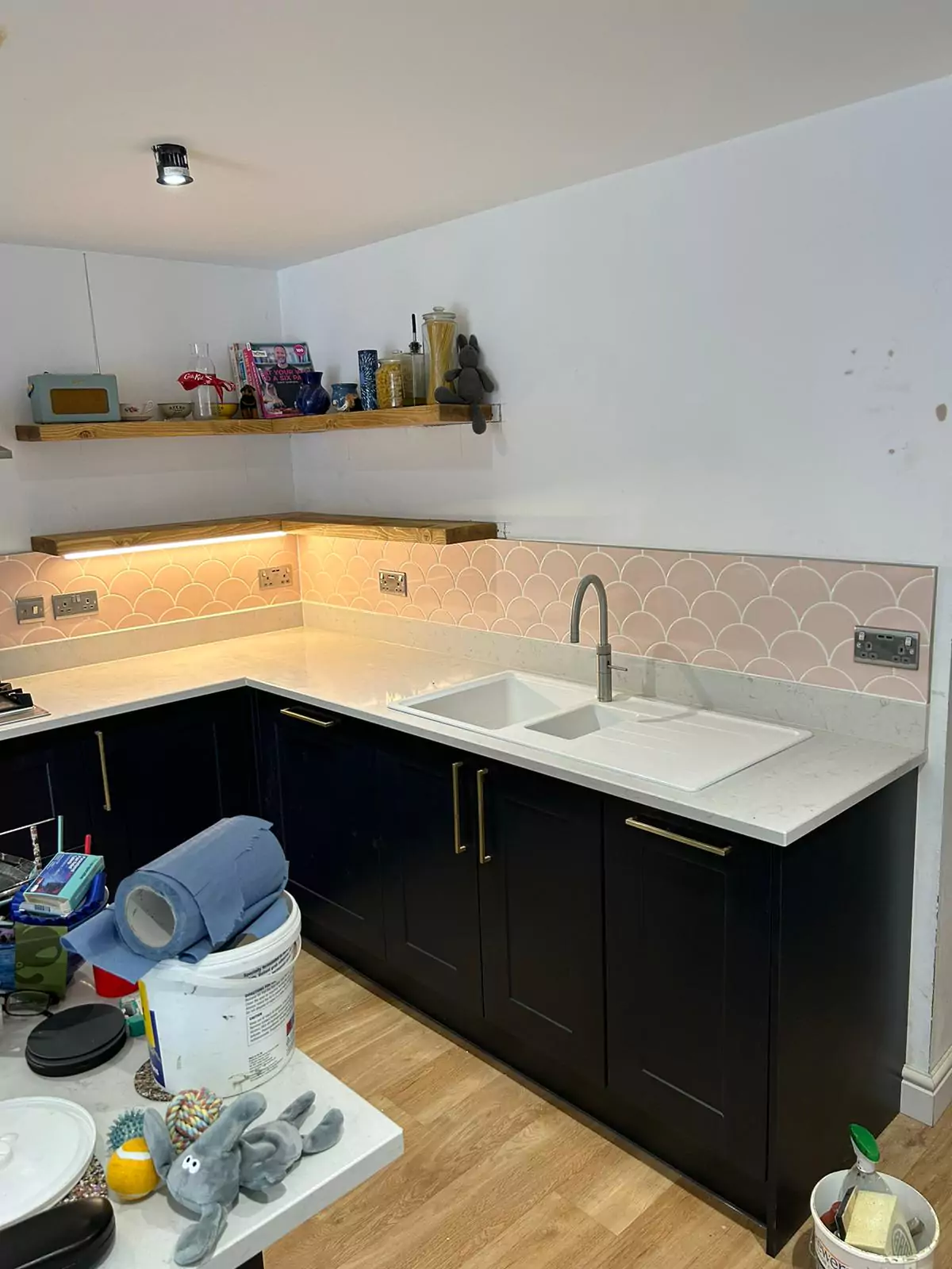 A kitchen with black cabinets and white counter tops.